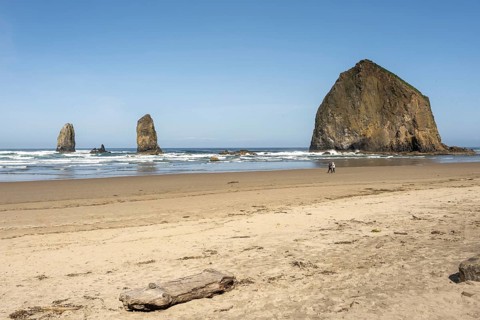 Sunny beach with large rocks in the sea and clear blue sky, peaceful and relaxing atmosphere,