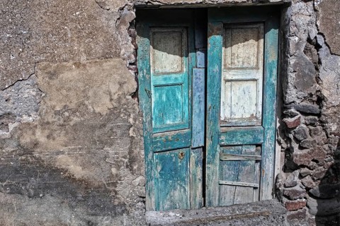 Old, weathered wooden doors in a stone, dilapidated wall, Stromboli Lipari Islands Sicily Italy
