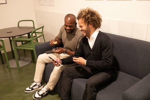 Two colleagues enjoying coffee and conversation in a modern coworking space in Barcelona, fostering