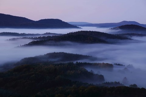 Landscape with mountains and clouds of fog in front of sunrise, nature photography, blue hour,