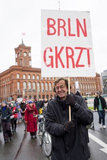 A participant holds a sign BRLN GKRZT at the #unkürzbar! Demonstration against the Berlin Senate's