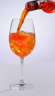 Aperol is poured into a glass against a white background