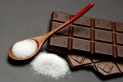 Chocolate and sugar bar in spoon, symbol of sugar consumption