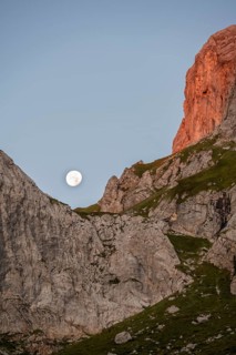 Moon behind rocky peaks at sunrise, alpenglow, Carnic High Trail, Carnic Main Ridge, Carnic Alps,
