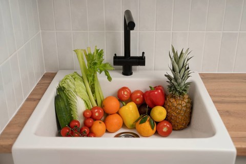 A vibrant collection of fresh fruits and vegetables, including tomatoes, celery, bell peppers, and