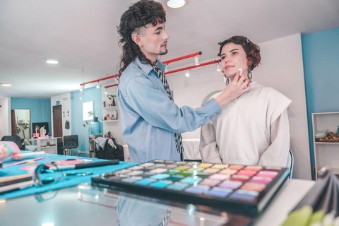 Professional makeup artist carefully applying foundation on a model's face. Preparing her for a