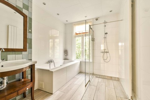 Features a sleek design with dual fixtures, natural lighting from a window, and a clean, tiled