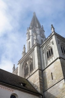 The imposing tower of Constance Cathedral, cathedral tower, bell tower, surrounded by clouds of