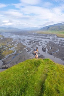 Hiker, Young woman on a hill, view over alluvial land, meandering river, Dímonarhellir, Suðurland,