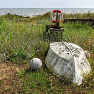 Inverted weathered boat, buoy, winch, lifebuoy on the shore, berth, fishing spot, Norebod
