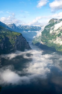 View over the Geirangerfjord, atmospheric clouds over the fjord in the morning light, Ørnesvingen