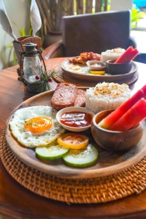 Delicious filipino breakfast featuring rice, fried egg, luncheon meat, watermelon, tomato,