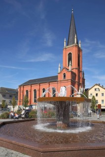 Fountain on train station square with Lutheran church in Limburg, Hesse, Germany