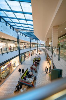 Modern shopping street in the shopping centre with glass roof and various shops, Sterncenter
