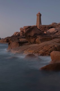 Lighthouse Mean Ruz at Ploumanach, Cotes d'Armor in the last evening light, with light on