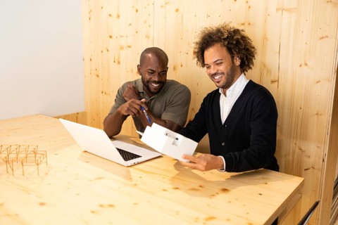 Two professionals collaborate in a modern coworking space in Barcelona. They engage in a productive