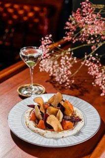 A vibrant root vegetable salad featuring beets, sweet potato, and artichoke, elegantly served with