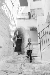 Boy runing in stairs in the city Ostuni in Plugia, Italy - commonly referred to as the White Town
