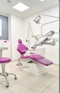 A modern dental clinic equipped with a sleek purple dental chair and advanced medical equipment,