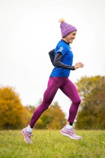 Happy woman jogging in autumn forest with vivid colours, Gechingen, Black Forest, Germany
