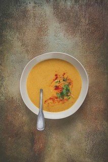 Pumpkin cream soup, in a white bowl on a textured background, top view, homemade, no people, rustic