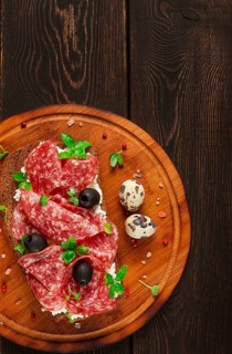 Sandwich, grain bread, with cream cheese and salami, black olives, micro-greens, top view,