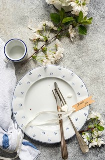 An elegant spring table setting features a vintage plate, fork, and knife adorned with a Thank you