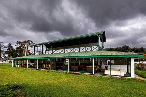 Modern building with large areas of glass and green roof against a cloudy sky, The Nuwara Eliya Sri