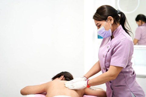 In a modern aesthetic clinic, a skilled therapist provides a relaxing massage to a client,