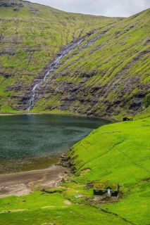 Grasstop roof house before a waterfall, Saksun, Streymoy, Faroe islands, Denmark