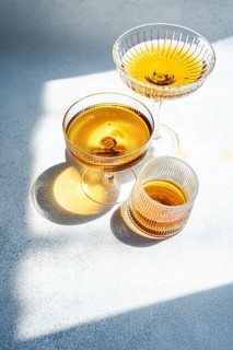 A still life of Georgian amber wine elegantly presented in three distinct glass styles. The light