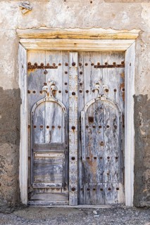 Old, weathered front door in the old, deserted neighbourhood of the town of Mirbat, Dhofar