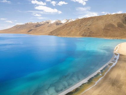 Breathtaking view of the serene Pangong Tso lake in Ladakh, India. The azure waters contrast with