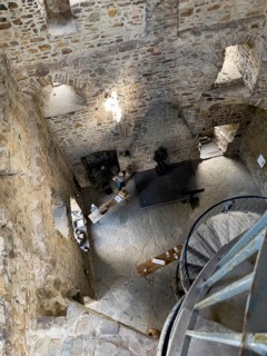 Dizzying view from spiral staircase steeply downwards in restored historic castle tower of