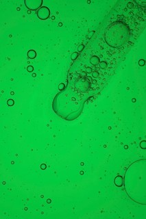 A close up macro shot of aloe vera oil for serum cosmetic, forming a vibrant abstract pattern. The