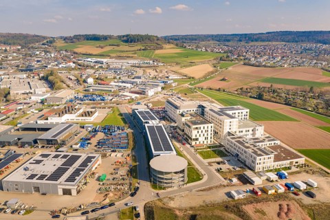 Panoramic view of a hospital complex surrounded by countryside and settlement, hospital opening,