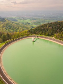 Upper reservoir, large water reservoir in a hilly landscape surrounded by dense forests, Glems