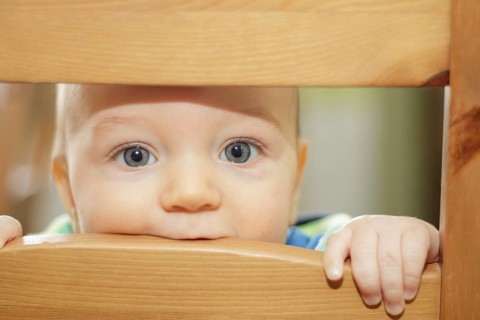 Small kid hiding on the chair back. Poznan, Poland