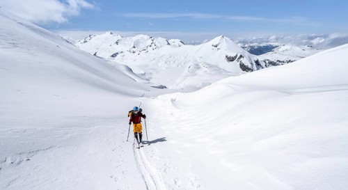 Ski tourer in mountain landscape with snow, behind summit Mittaghorn and Wildhorn, ascent to