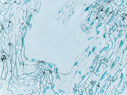 Aerial view of frozen lake Prestesteinsvatnet, melting snow creates small blue pools on the frozen