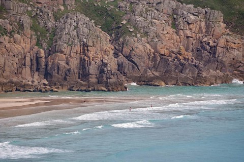 Näherer Blick auf eine felsige Küste mit kleinen Wellen am Strand, Porthcurno, St Levan, Cornwall,