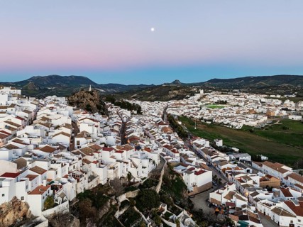 The White Town of Olvera with full moon at dusk. Aerial view. Drone shot. Cádiz province,