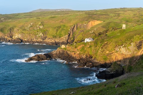 Landscape. On the headland of Gurnard's Head, view along the coast to Treen Cove with a house and