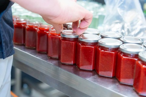 Manual sealing of jam jars in rows on a table, jam production, Haselstaller Hof, Wildberg