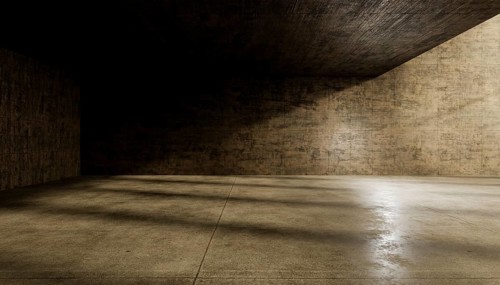 An abstract view of an empty concrete room with textured walls and floor, illuminated by dramatic