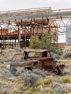 Destroyed car in front of abandoned Swift factory, The Swift refrigerator in Puerto San Julián,