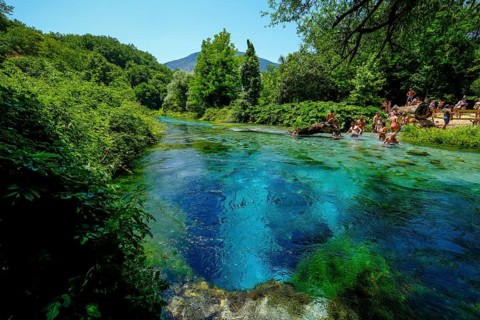 Muzina, Albania, tourists bathe in the Syri i Kaltër, THE BLUE EYE, is the country's most
