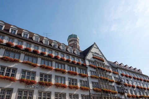 Red flowers bloom in flower boxes on the facade of the Hirmer department stores', Munich, Bavaria,