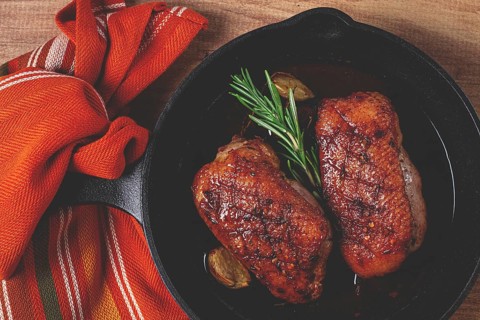 Roast duck breast, in a frying pan, with spices and herbs, close-up, no people
