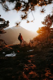 Hiker in the Allgäu at sunset in spring on the Zirmgrat near Pronten in the Allgäu